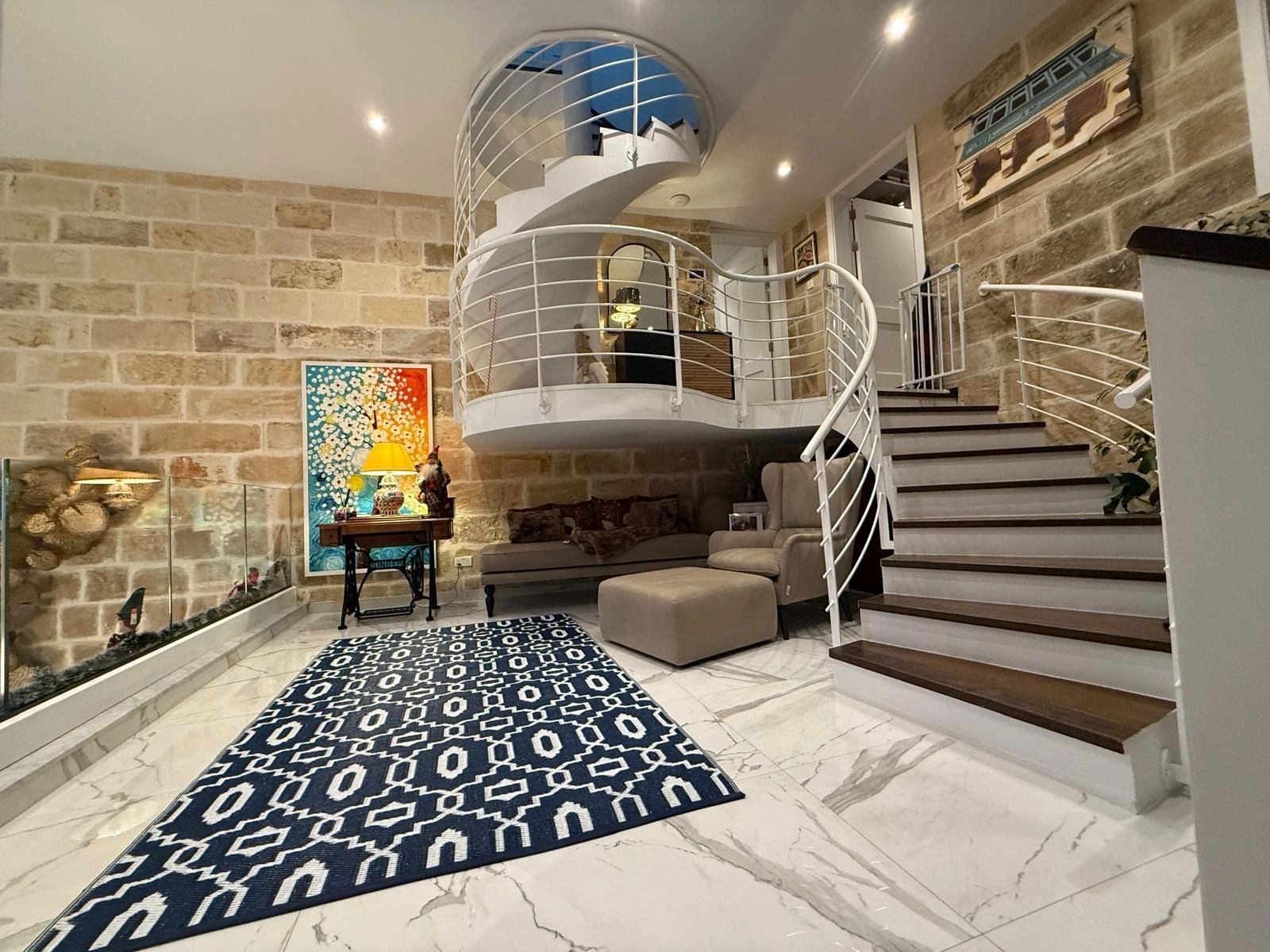 Entrance hallway with stone walls and a white spiral staircase